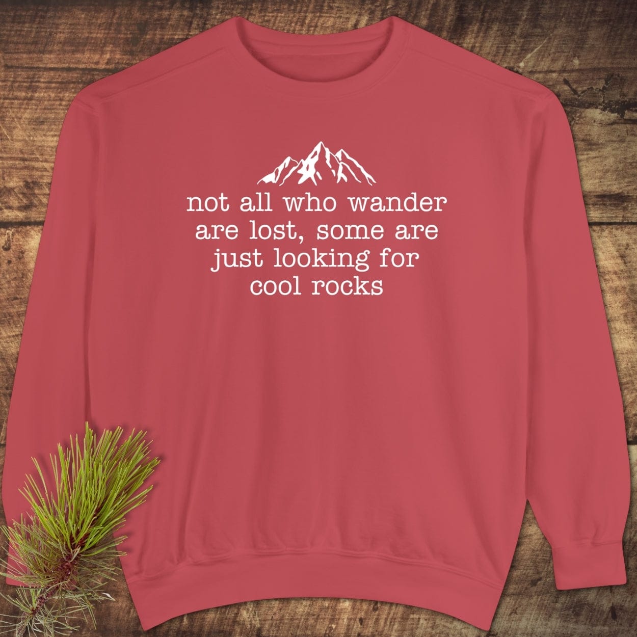 Looking For Cool Rocks Comfort Colors Sweatshirt featuring a mountain graphic and quote, laid flat. Made from 80% ring-spun cotton, offering luxurious comfort and relaxed fit.