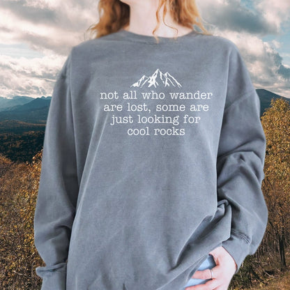 Person wearing a Looking For Cool Rocks Comfort Colors Sweatshirt, slate-gray, oversized with mountain silhouette, relaxed fit, standing in scenic mountain landscape.