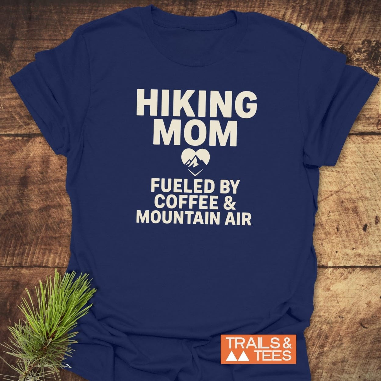 Navy-blue Hiking Mom Mountain Air T-Shirt with bold white lettering, heart-shaped mountain graphic. Crafted from soft cotton, showcasing outdoor adventure spirit.