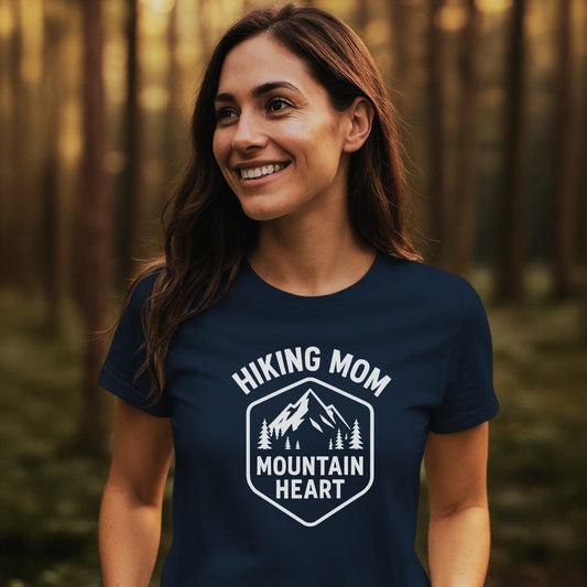Woman in forest wearing Hiking Mom Mountain Heart T-Shirt, showcasing mountain and pine tree badge design. Comfortable, durable cotton tee, ideal for outdoor enthusiasts.