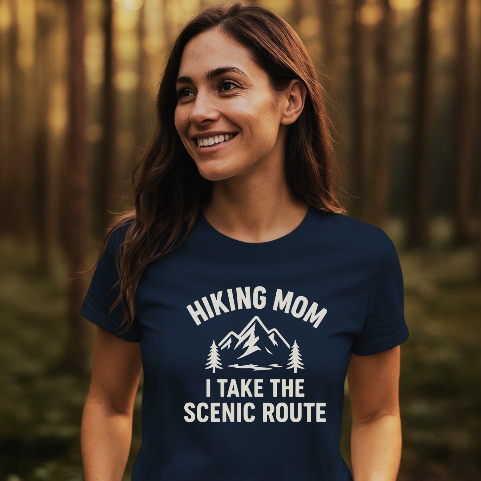 Hiking Mom, Scenic Route T-Shirt worn by a smiling woman in a forest, featuring a mountain graphic and slogan, ideal for adventure lovers.