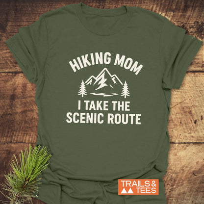 Hiking Mom, Scenic Route T-Shirt: Forest-green tee with mountain and pine graphic, “HIKING MOM, I TAKE THE SCENIC ROUTE.” Soft, durable, adventure-ready.
