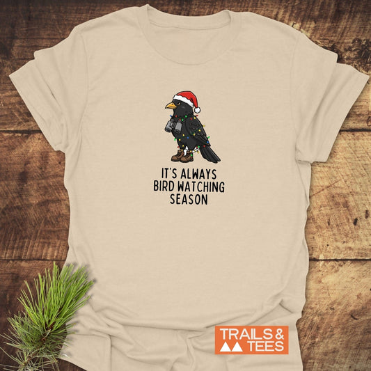 Always Bird Watching... T-Shirt featuring a cartoon blackbird in holiday gear, showcasing soft ring-spun cotton and durable print for outdoor enthusiasts.