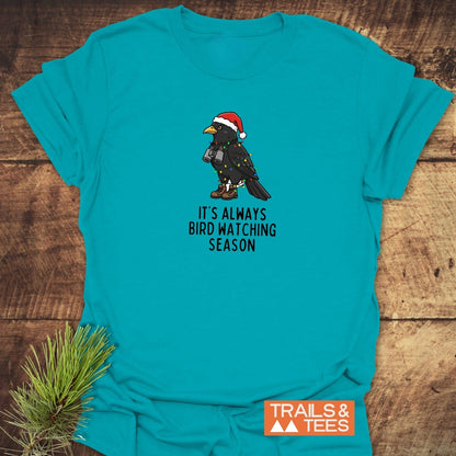 Always Bird Watching... T-Shirt featuring a cartoon bird in festive gear, highlighting its durability and comfort with DTF prints and pre-shrunk cotton.