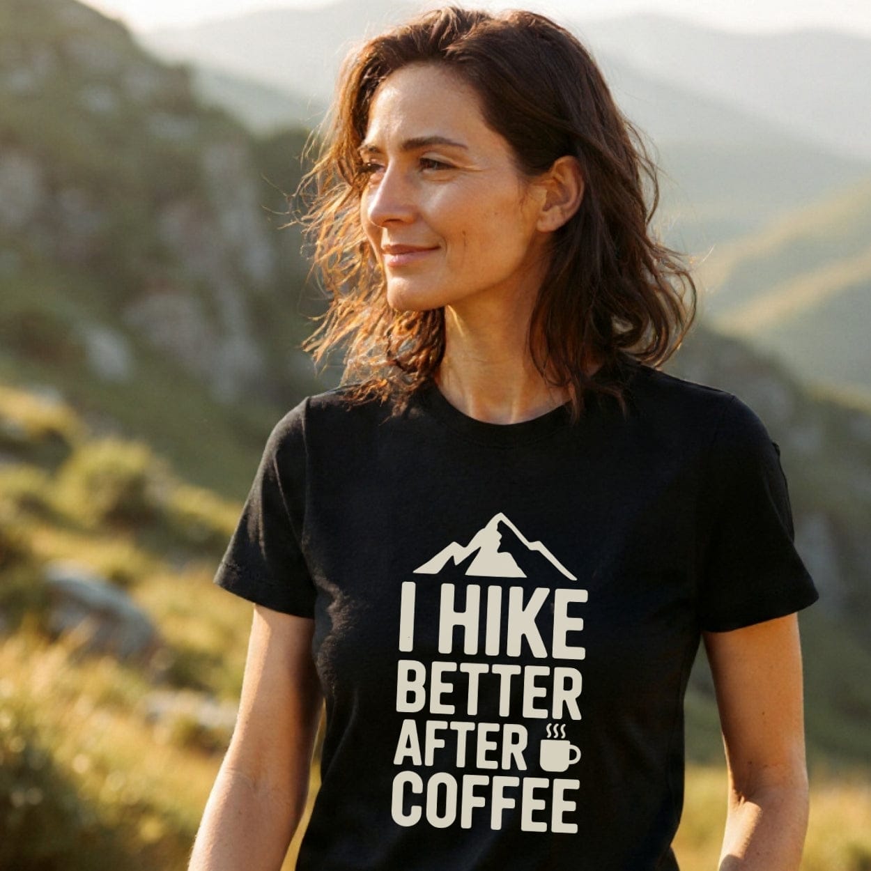 Woman outdoors wearing I Hike Better After Coffee T-shirt, featuring a mountain design and coffee cup. Captures the spirit of adventure with its soft, durable fabric, perfect for outdoor enthusiasts.