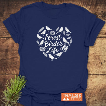 Forest Birder Life T-Shirt displayed on wood, featuring white graphic with songbirds, nests, and binoculars. Includes “TRAILS & TEES” logo. Made from soft ring-spun cotton for everyday outdoor adventures.
