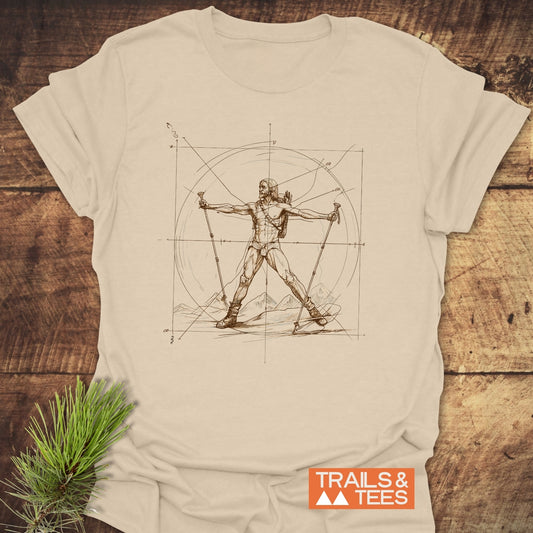 Vitruvian Hiker Da Vinci Style T-Shirt featuring a hiker in line-art, equipped with a backpack and trekking poles, set against a mountain range and geometric circle-square pattern, with TRAILS & TEES logo.
