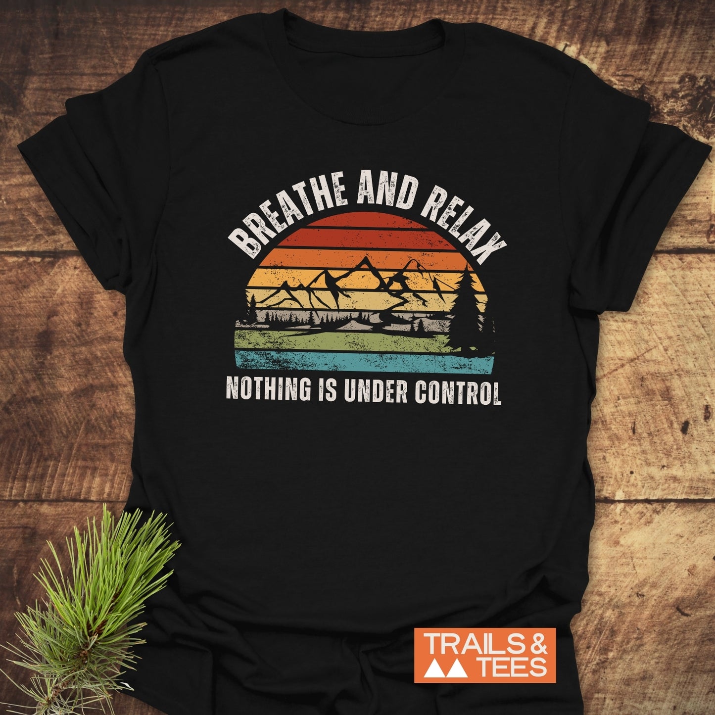 Breathe And Relax Funny T-Shirt with vintage sunset graphic, mountain silhouette, and Nothing is Under Control message, laid flat, showcasing its soft, durable, adventure-ready design.