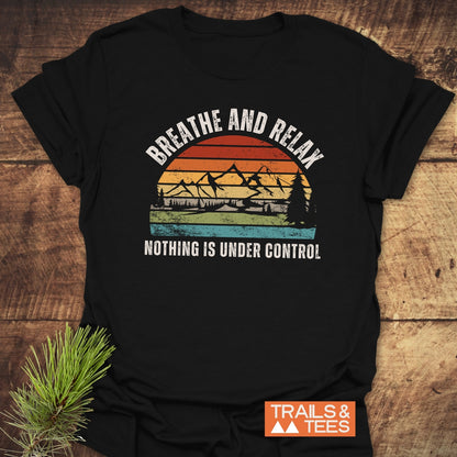 Breathe And Relax Funny T-Shirt with vintage sunset graphic, mountain silhouette, and Nothing is Under Control message, laid flat, showcasing its soft, durable, adventure-ready design.