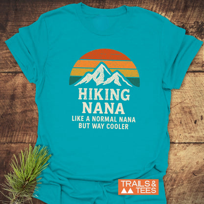 Hiking Nana Funny T-Shirt features a retro sun and mountain graphic with the phrase HIKING NANA Like a normal Nana but way cooler, ideal for outdoor enthusiasts.