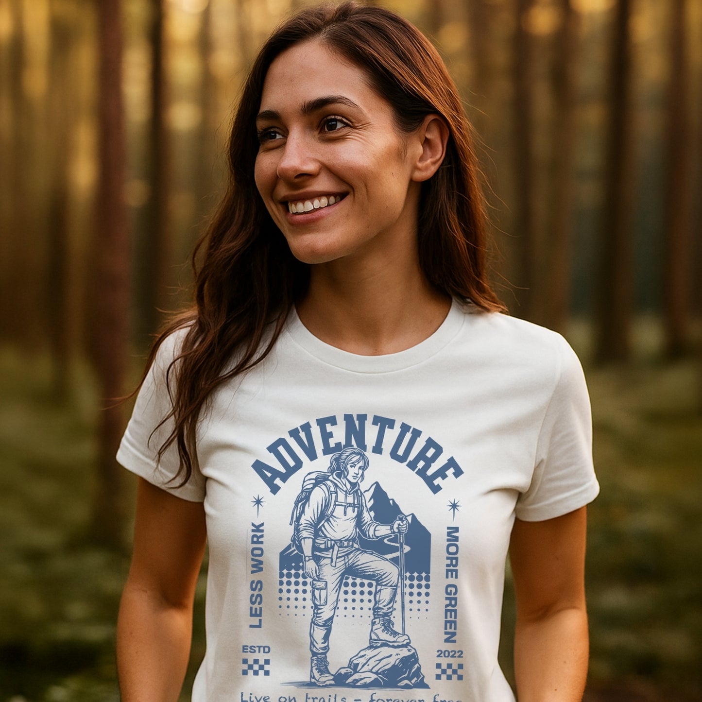 Woman wearing the Adventure Retro T-Shirt, featuring a backpacker graphic with LESS WORK, MORE GREEN and mountain silhouette, standing in a forest.