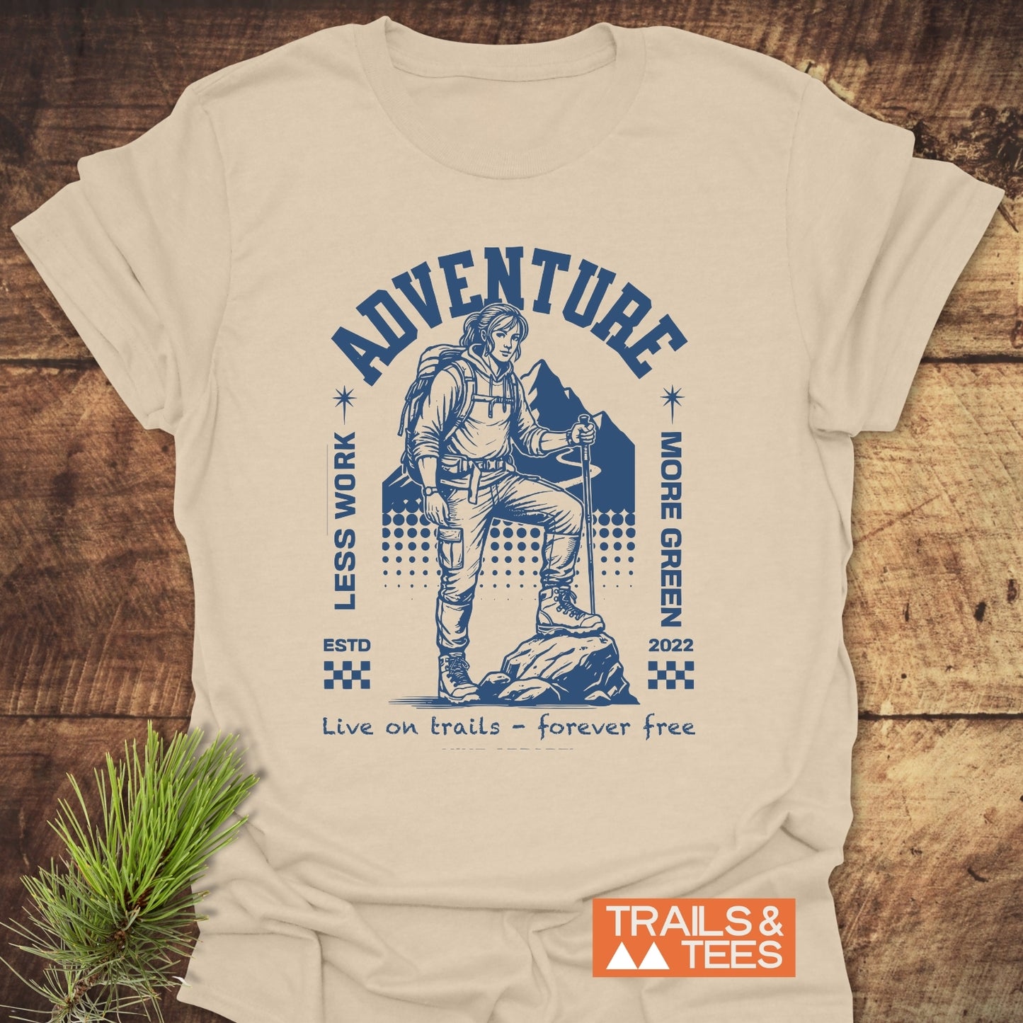 Adventure Retro T-Shirt featuring a navy graphic of a hiker with ADVENTURE above, LESS WORK and MORE GREEN on sides, and Live on trails – forever free below.