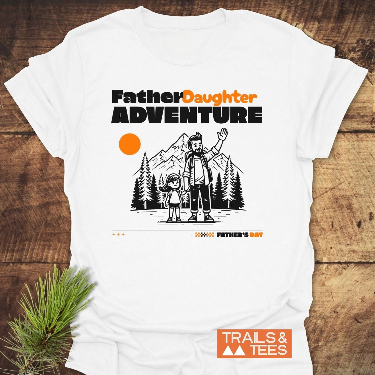 Father/Daughter Adventure T-Shirt featuring a cartoon dad and daughter amidst pine trees and mountains, with Father Daughter ADVENTURE text. Crafted from soft cotton, ideal for outdoor enthusiasts.