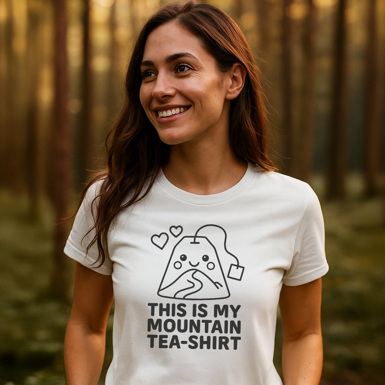 Young woman outdoors wearing Mountain Tea Shirt T-Shirt featuring a cartoon tea bag shaped like a mountain with hearts, captioned THIS IS MY MOUNTAIN TEA-SHIRT, ideal for outdoor adventures.