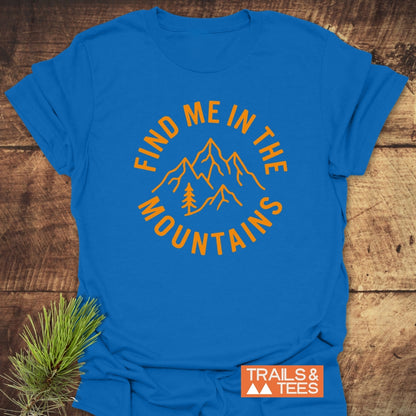 Find Me In The Mountains T-Shirt features mountain peaks and a pine tree graphic in orange, with a slogan. Made from soft, lightweight cotton, it offers comfort and durability for outdoor enthusiasts.