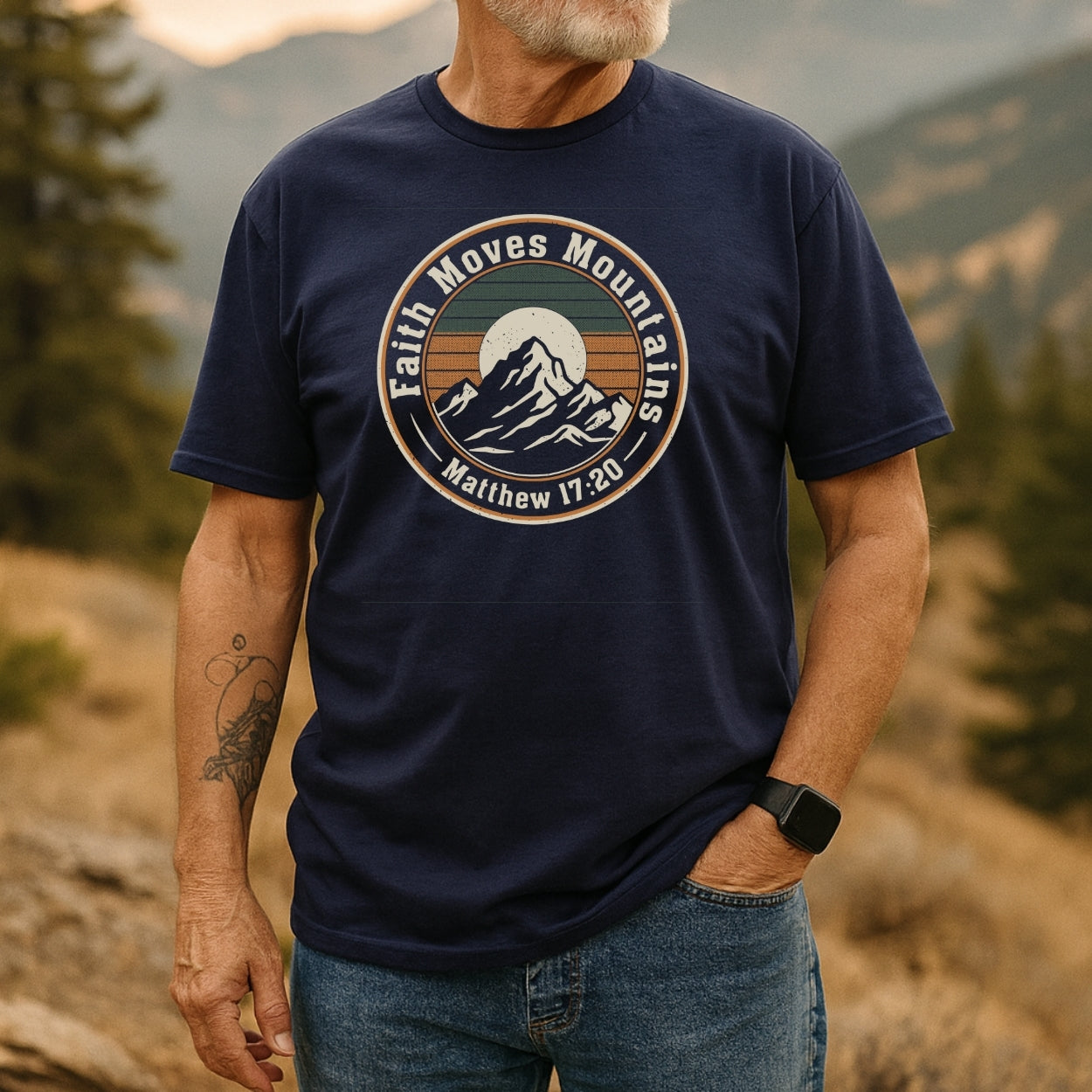 Bearded man in a Faith Moves Mountains T-Shirt with mountain graphic, standing outdoors. The shirt, made of soft cotton, highlights adventure spirit and durability, perfect for nature enthusiasts.