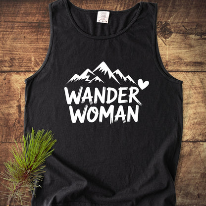 Wander Woman Comfort Colors 9360 Tank Top features a mountain silhouette and heart design. Displayed on wood with a pine sprig, this black tank is made of 100% ring-spun US cotton.