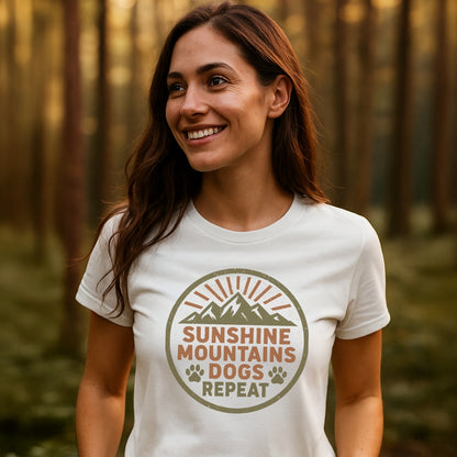 Woman in forest wearing Sunshine Mountains Dogs Badge T-Shirt, featuring sun rays, mountains, and paw prints. Celebrating outdoor adventures with soft, durable cotton, ideal for nature enthusiasts.