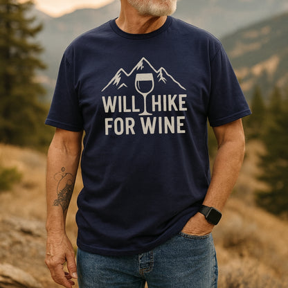 Person outdoors wearing a Will Hike For Wine T-shirt featuring a mountain and wine glass design. The shirt, made from soft ring-spun cotton, offers comfort and style for outdoor enthusiasts.