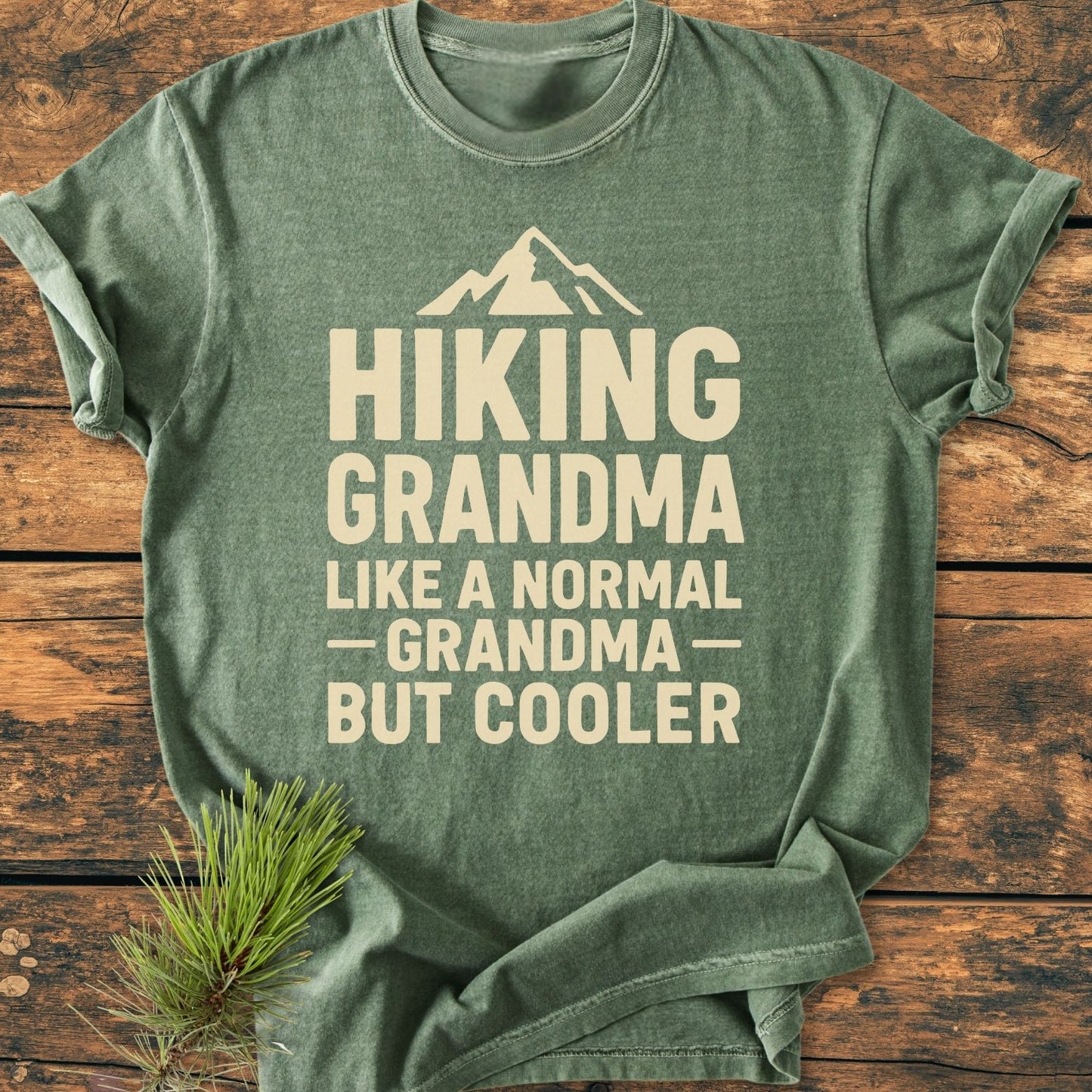 Hiking Grandma Vintage Wash Tee laid flat, featuring a stylized mountain icon and beige text. Made of soft, pre-shrunk, 100% ring-spun cotton, ensuring comfort and durability.