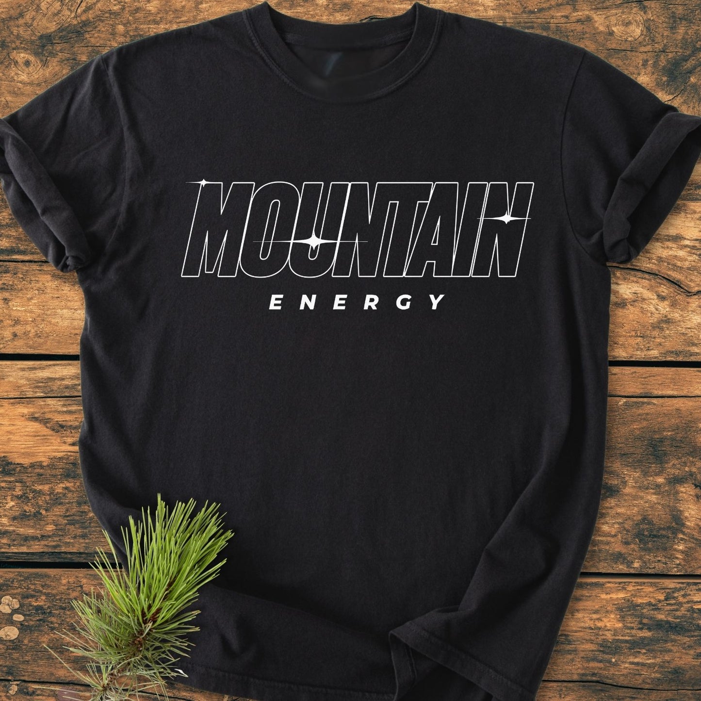 Mountain Energy Vintage Wash Tee displayed flat, featuring “MOUNTAIN ENERGY” print in bold white font on black. Made of soft, garment-dyed 100% ring-spun cotton, exemplifying relaxed fit and durability.