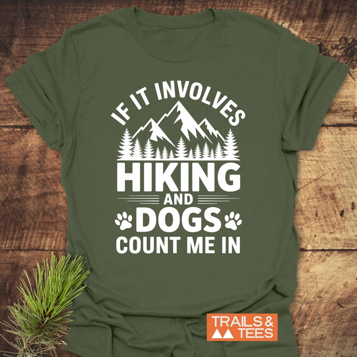 Hiking And Dogs T-Shirt featuring mountain peaks and dog paw prints graphic. Made from soft ring-spun cotton, perfect for outdoor enthusiasts. Includes durable print, taped shoulders, and pre-shrunk fit.