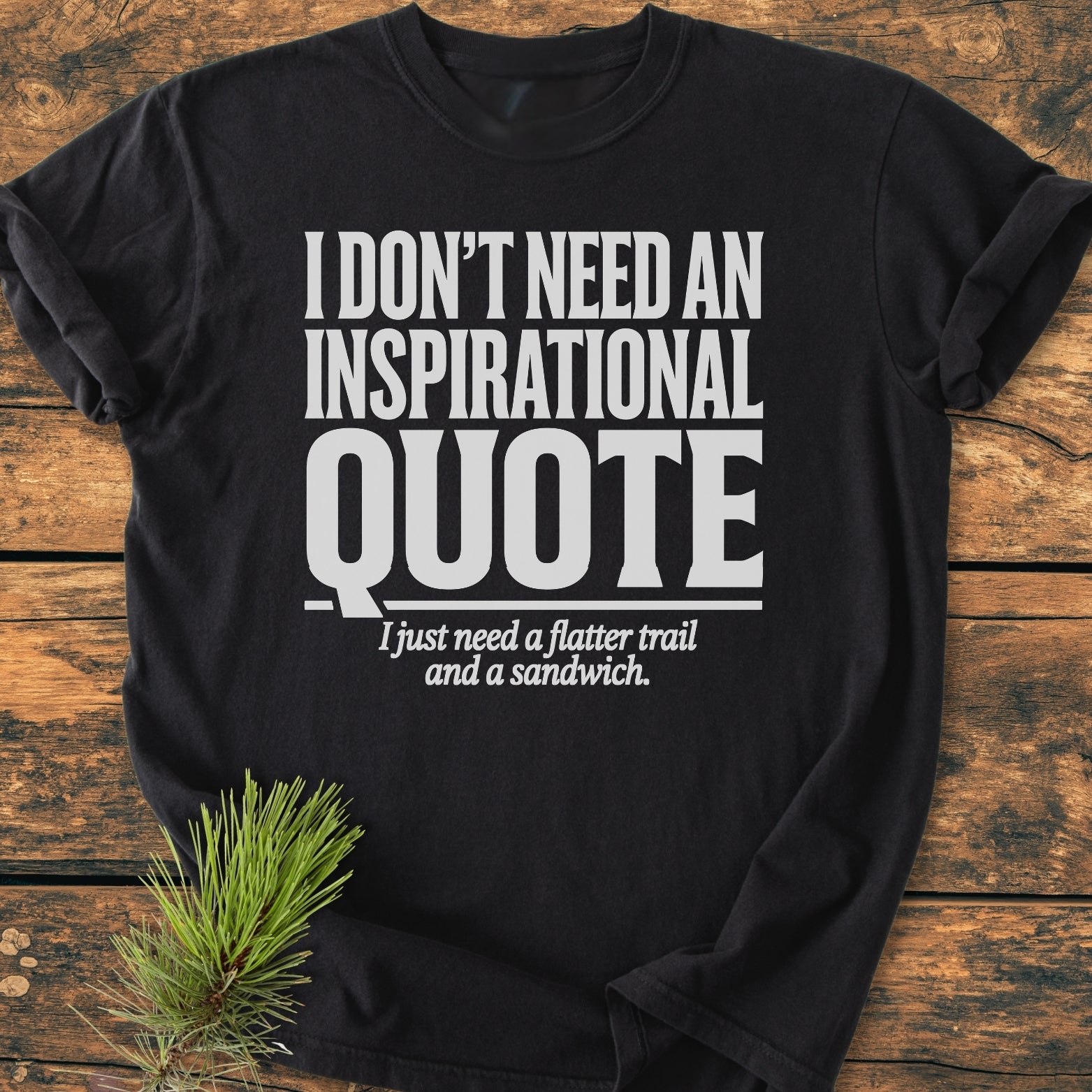 No Inspirational Quote - Vintage Wash Tee; a black crew-neck T-shirt with a bold white slogan, laid flat on wood, featuring a decorative pine sprig for a cozy, relaxed vibe.