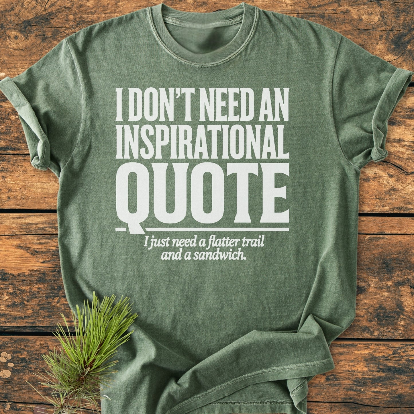 Heather-green No Inspirational Quote - Vintage Wash Tee featuring a bold white slogan, laid flat on wood with a pine sprig, highlighting its relaxed fit and soft-washed, durable cotton fabric.