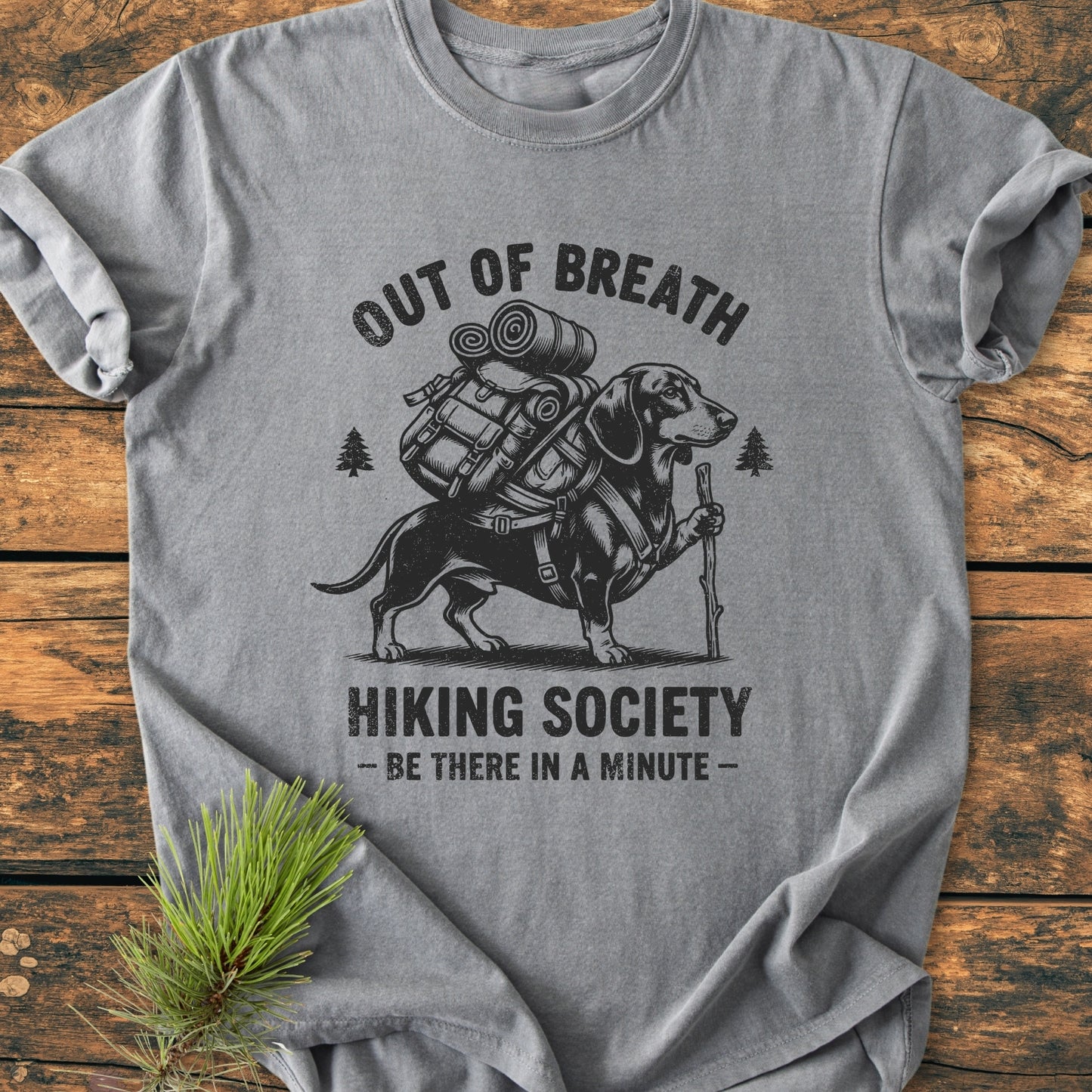 Out Of Breath Dachshund - Vintage Wash Tee features a dachshund in hiking gear with the slogans “OUT OF BREATH” and “HIKING SOCIETY – BE THERE IN A MINUTE –, on a heather-gray T-shirt.
