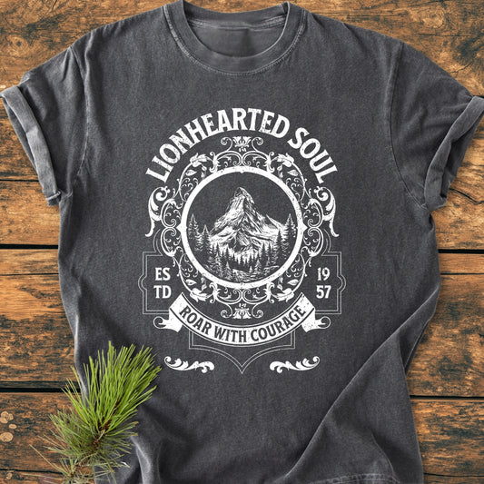 Lionhearted Soul - Vintage Wash Tee displayed flat, featuring a white, vintage-style graphic with mountains and pine trees, encircled by Est. 1957 and Roar with Courage banner on charcoal-gray fabric.
