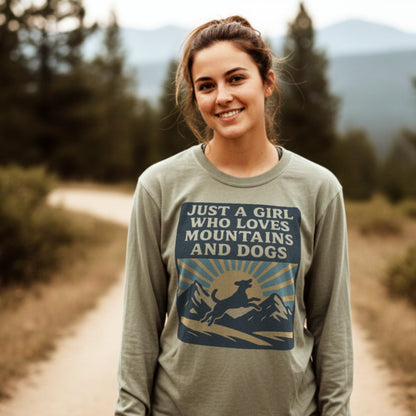Young woman wearing Just A Girl Who Loves Mountains and Dogs Comfort Colors Long-Sleeve Tee, featuring mountain and dog graphic, on a forest trail. Relaxed fit, 100% ring-spun cotton.
