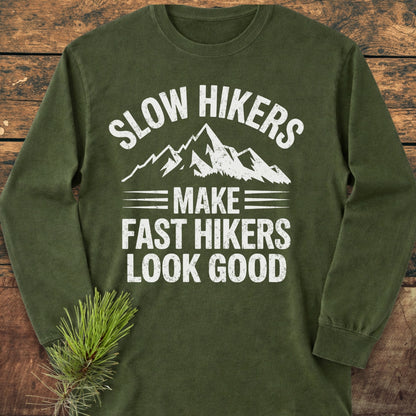 Forest-green Slow Hikers Make Fast Hikers Look Good long-sleeve tee, laid flat, featuring a distressed mountain print. Made from 100% ring-spun cotton, it's soft, stylish, and perfect for casual settings.