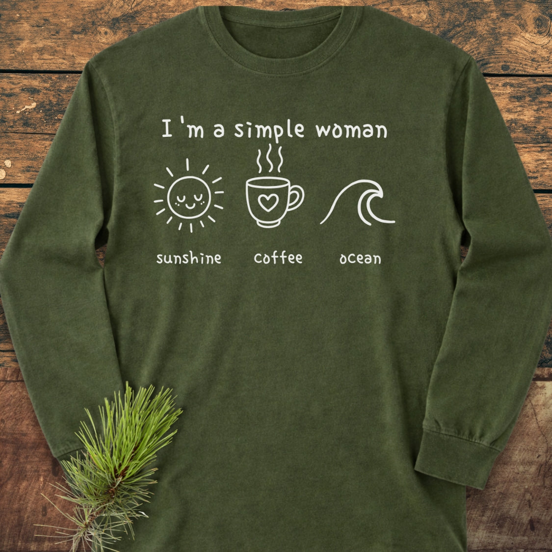 I'm A Simple Woman - Sunshine Coffee Ocean Long-Sleeve Tee, forest-green, laid flat with icons and text in white line art. Includes a sun, mug, and wave on chest, with pine sprig accent.