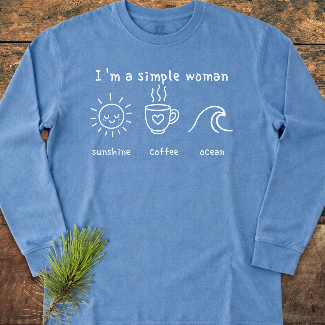 I'm A Simple Woman - Sunshine Coffee Ocean Long-Sleeve Tee features hand-drawn-style graphics on a light-blue cotton shirt, showcasing a sun, coffee mug, and ocean wave doodles.