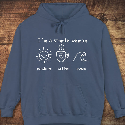 I'm A Simple Woman - Sunshine Coffee Ocean Hoodie, featuring a white hand-drawn graphic on the chest, laid flat against a wooden background, showcasing its relaxed, cozy design ideal for layering.
