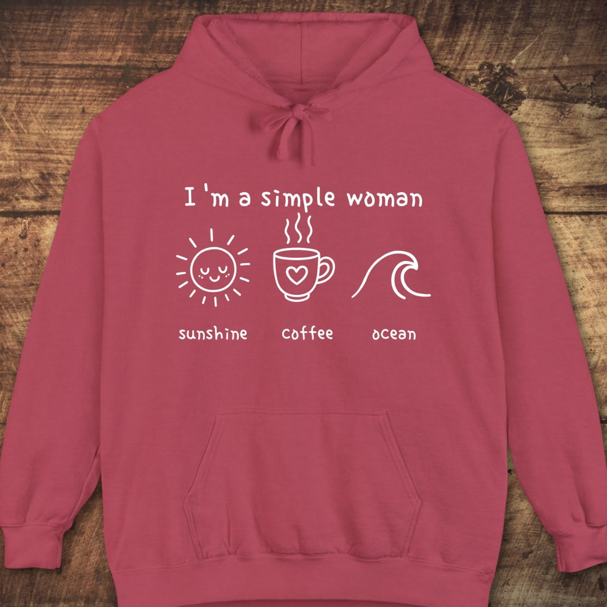 I'm A Simple Woman - Sunshine Coffee Ocean Hoodie featuring white hand-drawn icons and text on the chest, laid flat on a wooden backdrop, showcasing its cozy, relaxed, and vintage-inspired design.