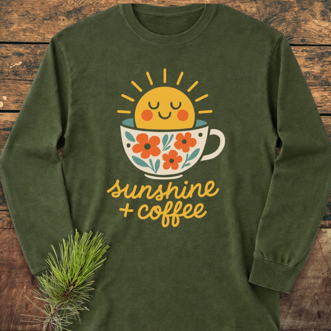 Sunshine And Coffee Long-Sleeve Tee features a cute sun graphic in a floral coffee cup with the phrase sunshine + coffee, offering a relaxed fit and softness in 100% ring-spun cotton.
