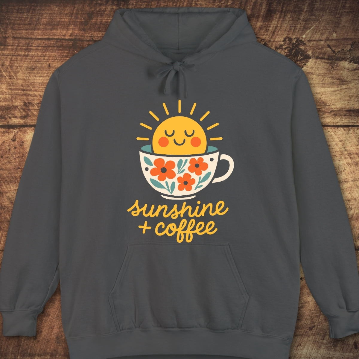 Sunshine And Coffee Hoodie: Dark-gray pullover with a cheerful sun-in-coffee-cup graphic and sunshine + coffee text, offering a relaxed fit, perfect for cozy layering on adventures.