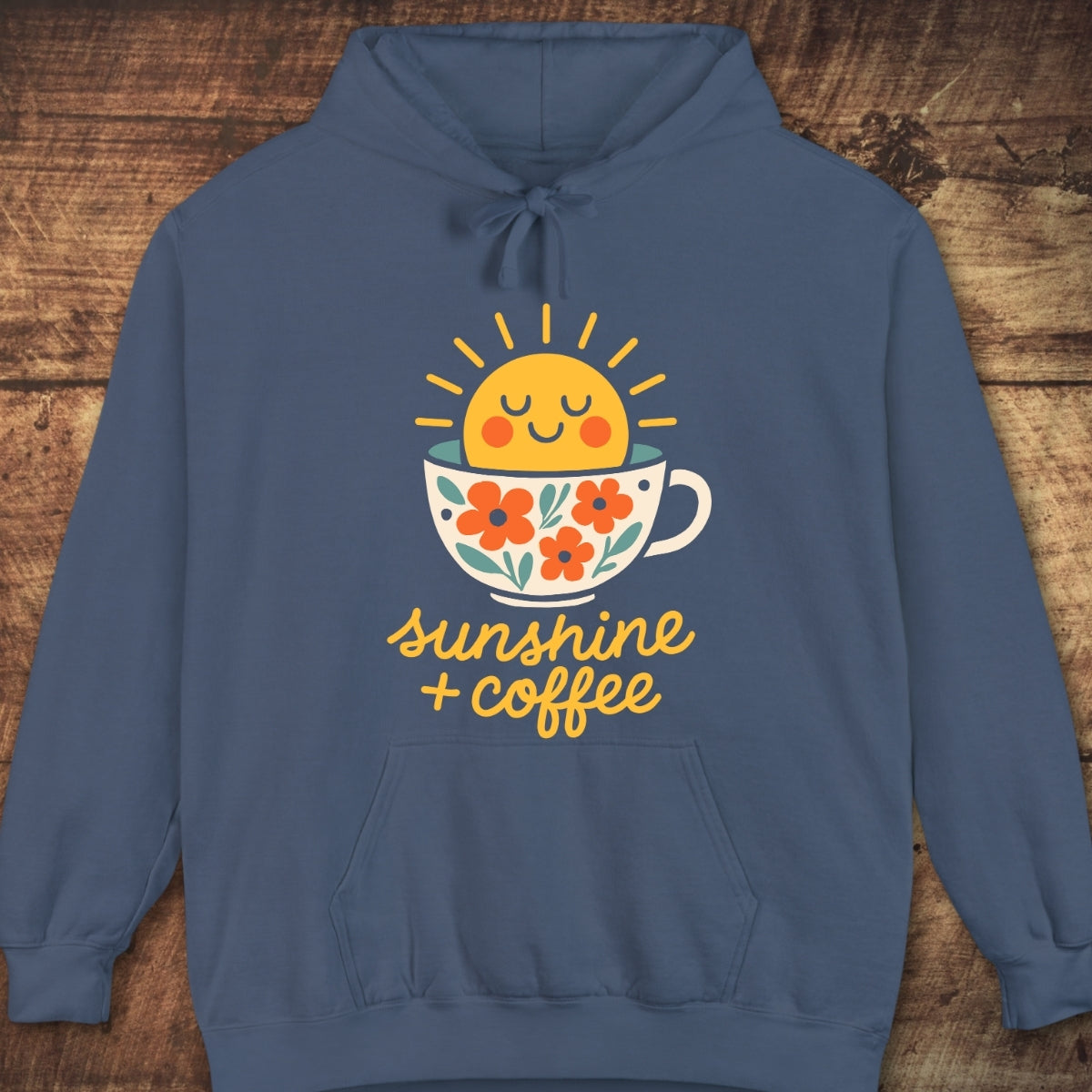Sunshine And Coffee Hoodie featuring a cheerful sun rising from a floral-decorated coffee cup graphic, capturing trail mornings' comfort with its relaxed fit and soft fleece fabric.