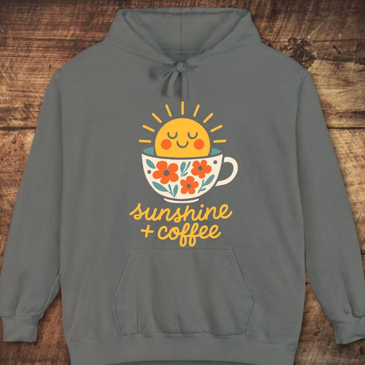 Sunshine And Coffee Hoodie: Gray pullover with a cheerful sun and coffee cup graphic, featuring sunshine + coffee text. Soft cotton-poly blend, relaxed fit, perfect for cozy layering and outdoor adventures.
