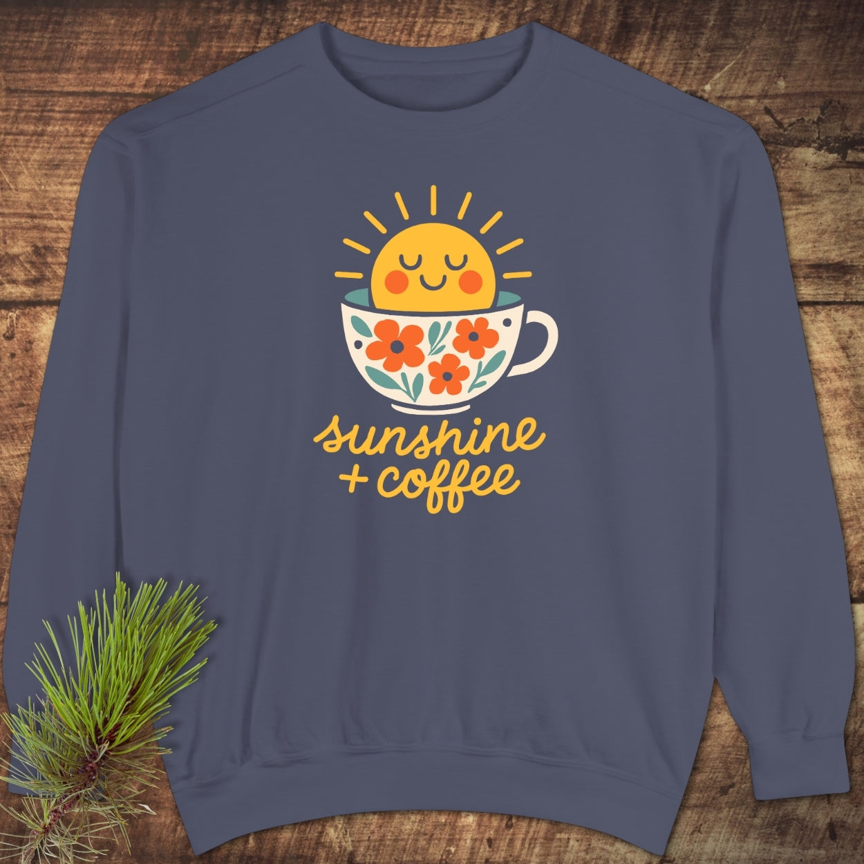 Sunshine And Coffee Sweatshirt featuring a smiling sun in a floral coffee cup with radiating beams. Laid-flat with relaxed fit, rolled-forward shoulder, and back neck patch, ideal for comfort and style.