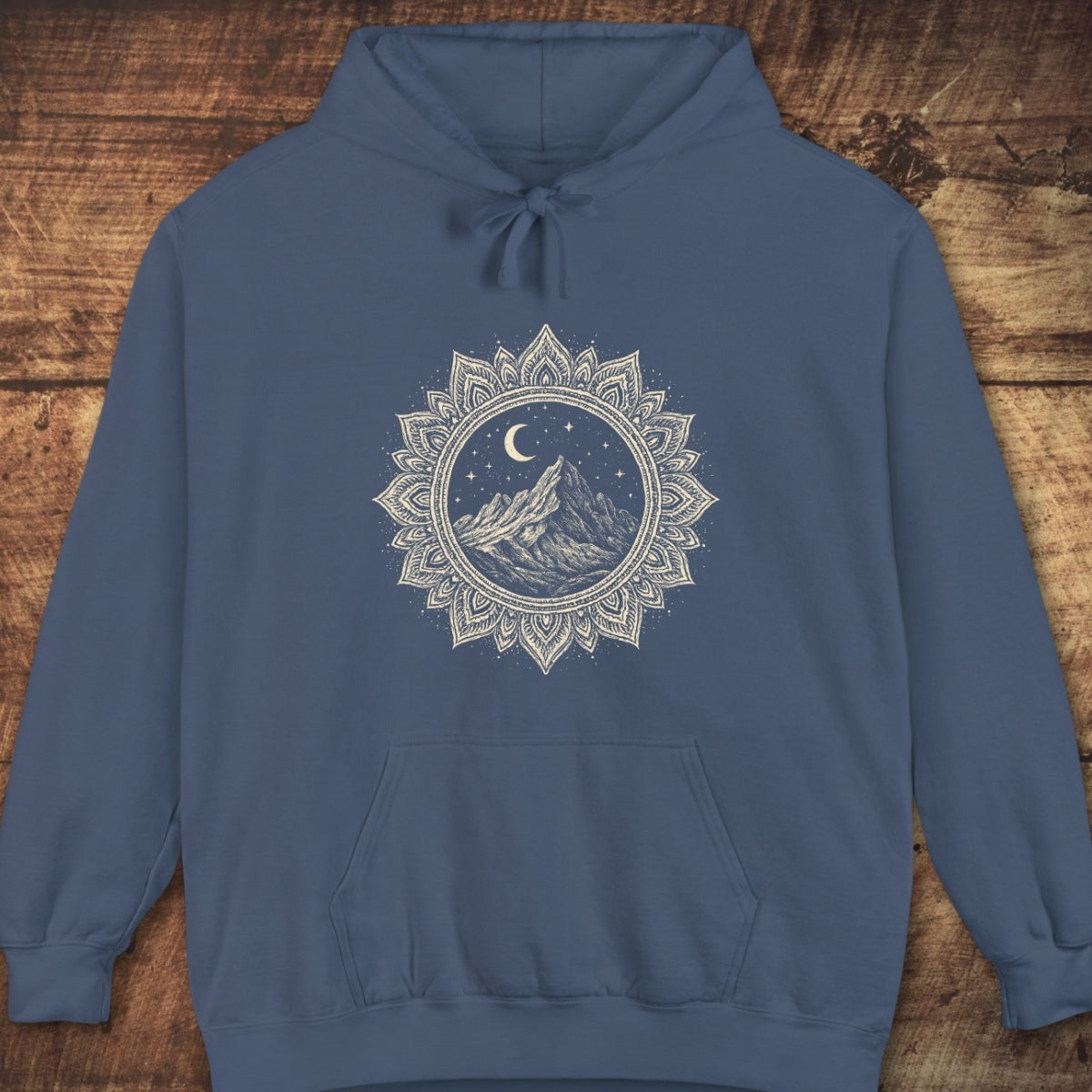 Mountain Mandala Hoodie featuring a hand-drawn mountain peak under a crescent moon and stars, encircled by a mandala-style border. Includes a kangaroo pocket and drawstring hood for relaxed, trail-inspired comfort.