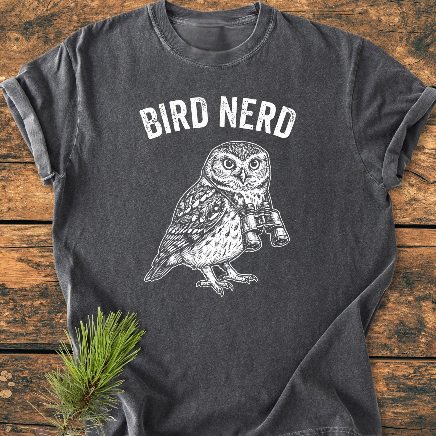 Bird Nerd Owl - Vintage Wash Tee featuring an owl with binoculars print on charcoal-gray, laid on wood. Made from soft, 100% ring-spun cotton, offering comfort and durability in a relaxed fit.