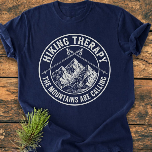 Hiking Therapy - Vintage Wash Tee showcasing a graphic of mountains and trekking poles with phrases, laid on wood. Features soft-washed, ring-spun cotton for comfort and durability, perfect for everyday wear.