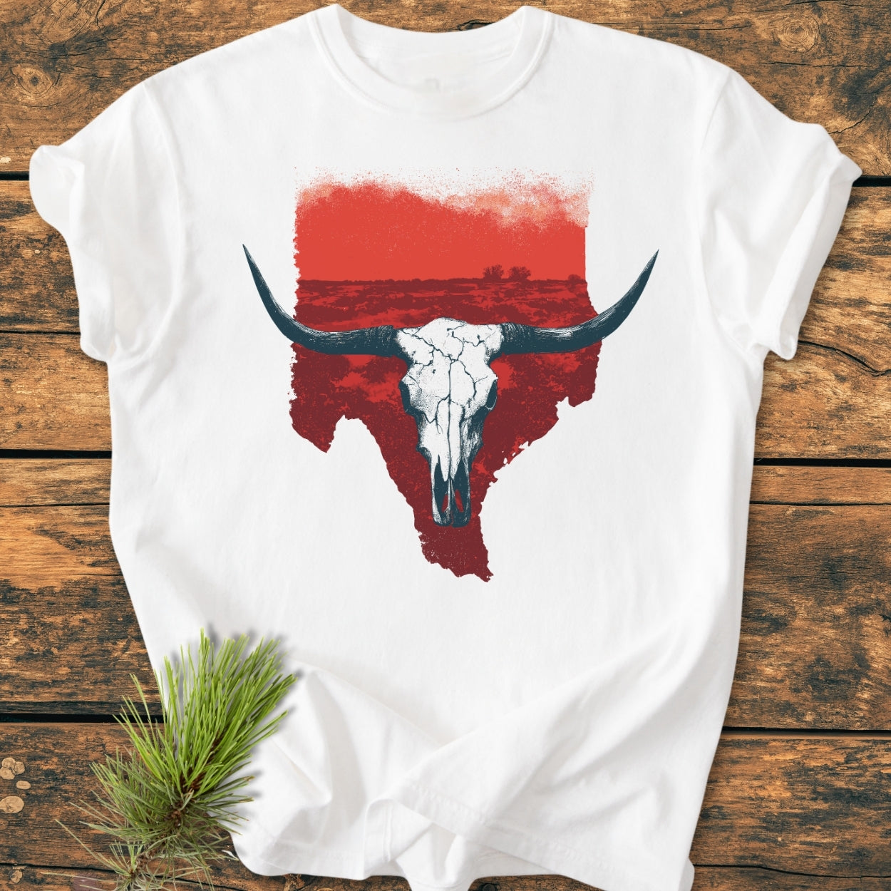 Hike Texas - Vintage Wash Tee featuring a distressed red Texas silhouette with a weathered longhorn skull design, laid flat on rustic wood. Perfectly soft and relaxed fit for everyday wear.