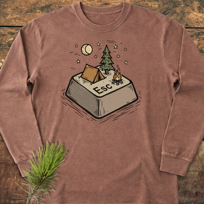Escape Long-Sleeve Tee features a graphic of a campsite-themed Esc key with a tent, pine tree, and campfire, laid on wood with a pine sprig accentuating its cozy, adventure-inspired design.