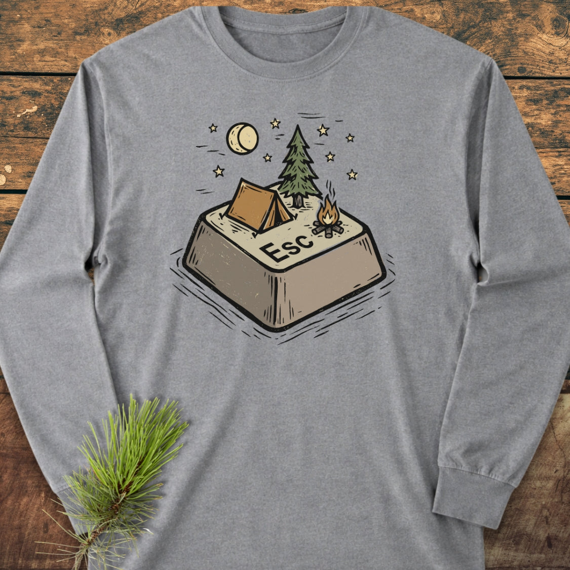 Escape Long-Sleeve Tee features a whimsical illustration of an “Esc” key campsite with a tent, pine tree, and campfire, offering a playful take on the concept of escape.