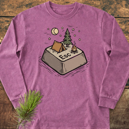 Escape Long-Sleeve Tee featuring an oversized Esc key with a campsite scene, laid flat on wood, accompanied by a pine sprig, highlighting its soft, garment-dyed 100% ring-spun cotton construction.