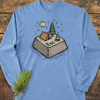Escape Long-Sleeve Tee features a playful campsite illustration atop a giant Esc key. Laid flat on a wooden surface, this heather-blue shirt offers softness and style with its relaxed fit.