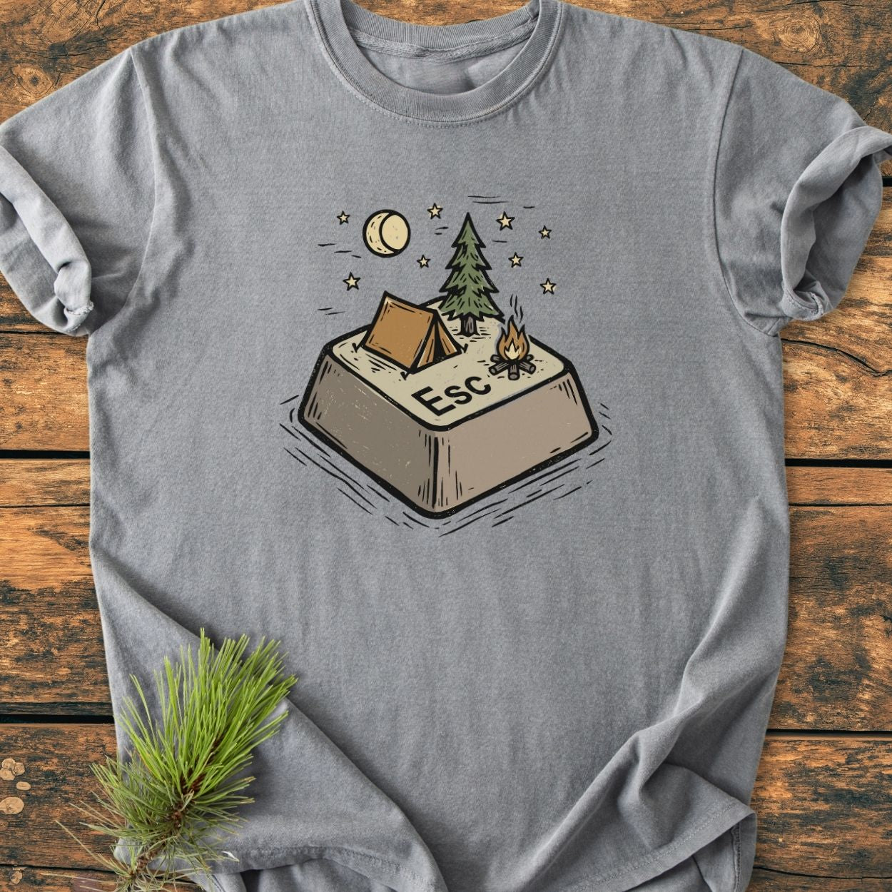 Escape - Vintage Wash Tee features a playful camping scene on a gray T-shirt, with a tent, pine tree, campfire, and moon on a stylized “Esc” key, evoking outdoor adventure.